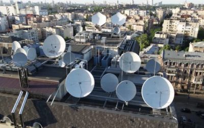 This stock video shows an aerial view of a circular TV antenna on the roof of a building.